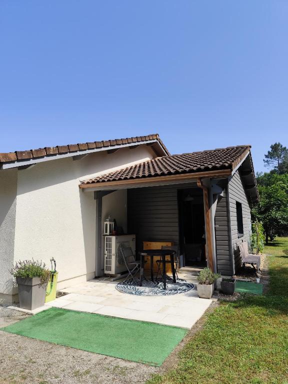 una piccola casa con patio e tavolo di Le petit nid dans les bois a Castres-Gironde