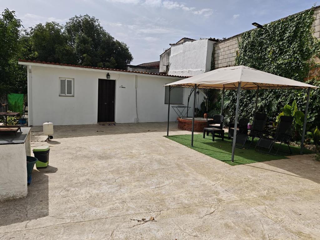 a patio with an umbrella and a building at Villa Verde Pet-friendly in Córdoba