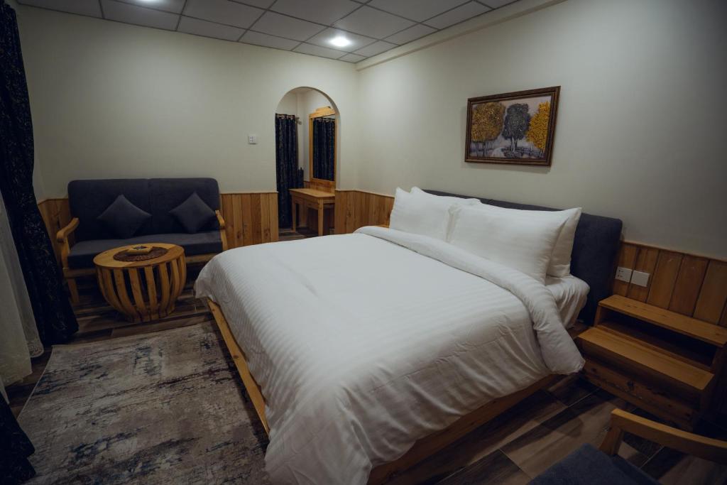 a bedroom with a large white bed and a chair at Azure Lagoon Resort 