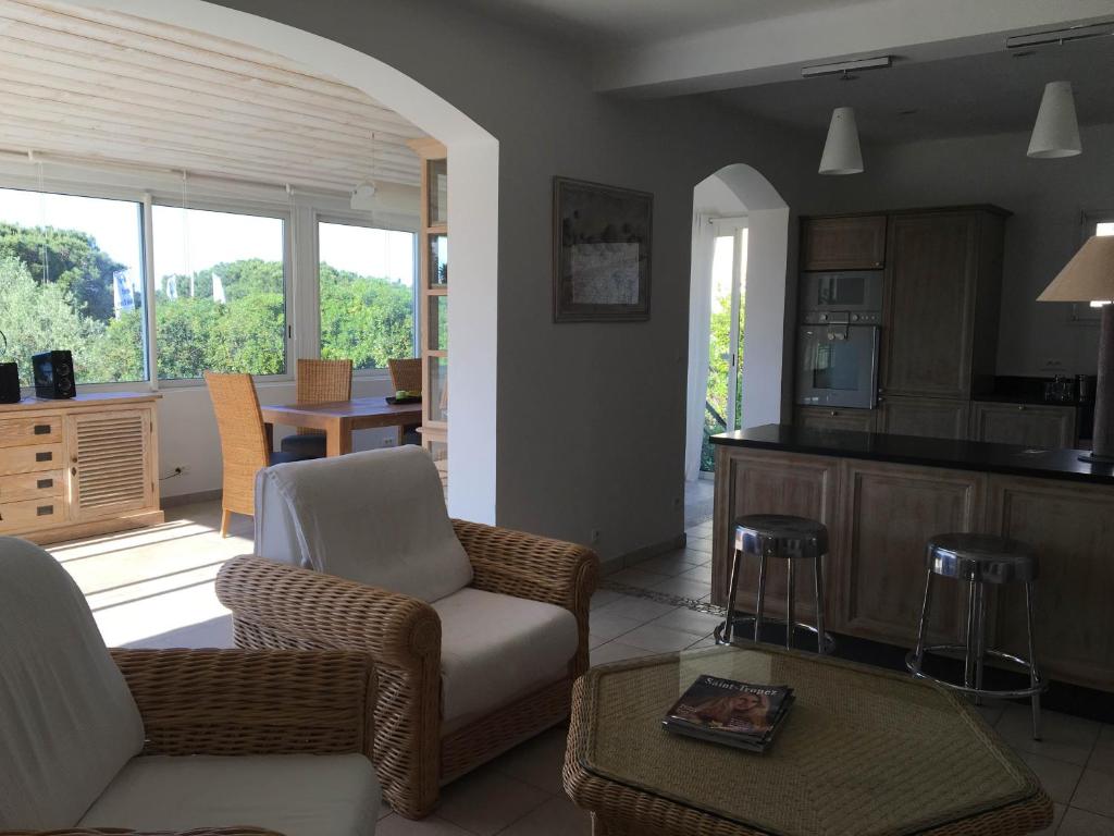a living room with a couch and chairs and a kitchen at Hotel Villa Maya in Saint-Tropez