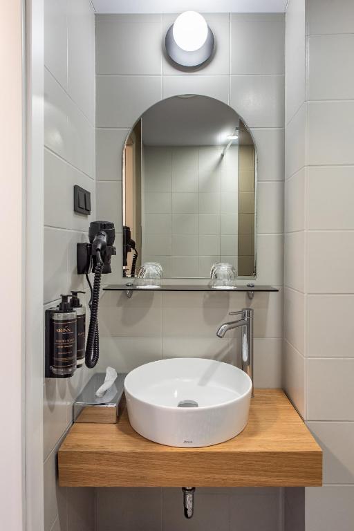 a bathroom with a sink and a mirror at AIRINN Vilnius Airport Hotel RENOVATED 2025 in Vilnius