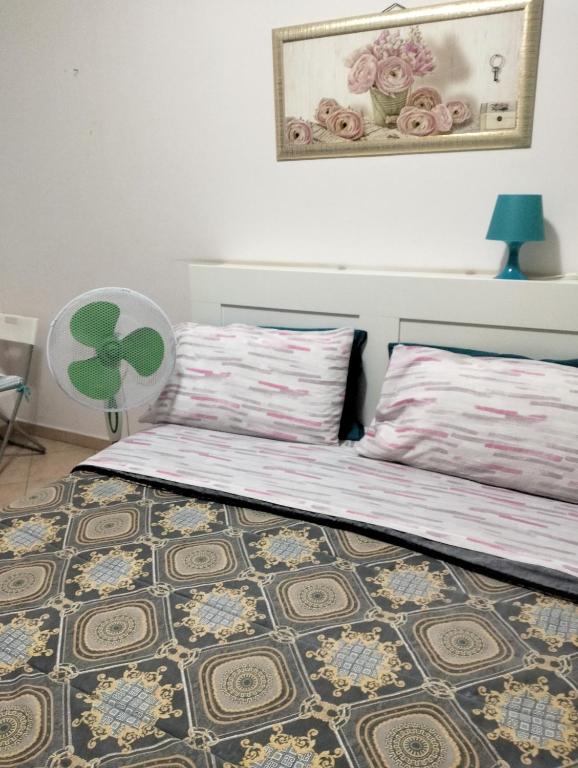 sypialnia z 2 łóżkami, stołem i wentylatorem w obiekcie La Perla B & B w Ciampino
