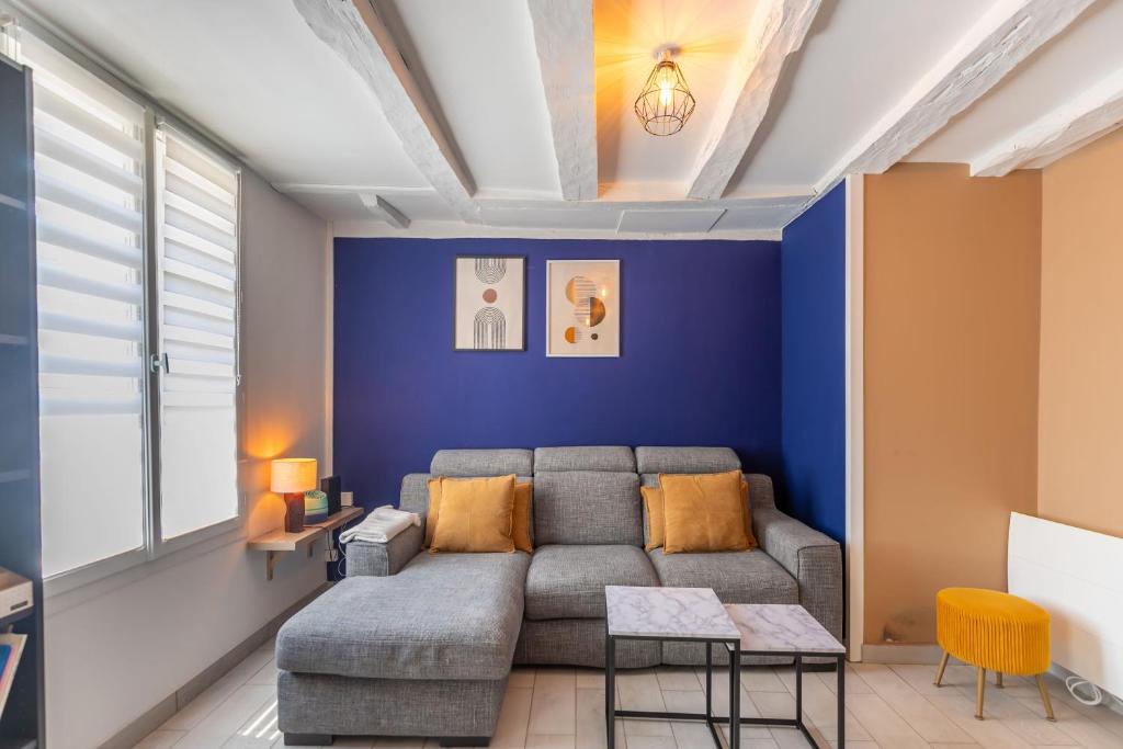 un salon avec un canapé et un mur bleu dans l'établissement La Pierre Blanche - Maison Familiale, à Saint-Georges-sur-Cher