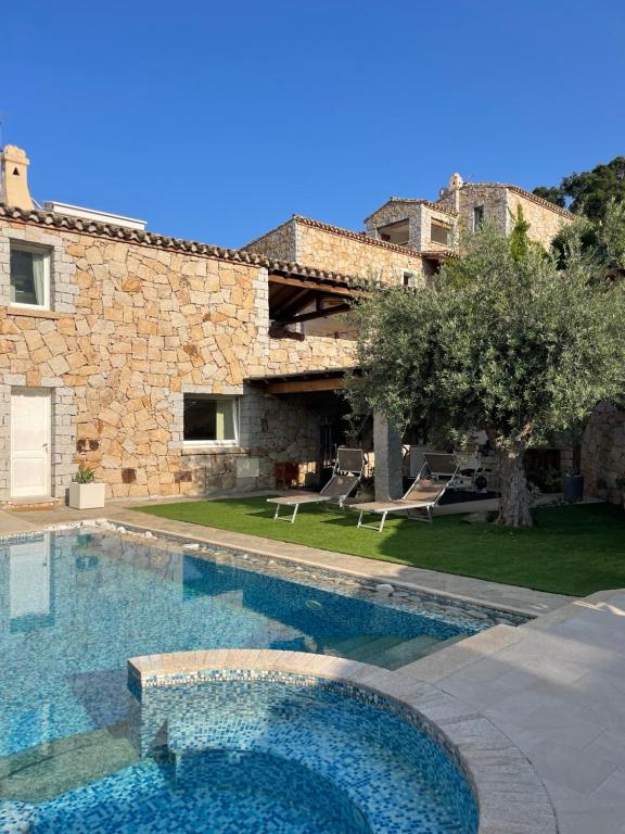a large swimming pool in front of a house at Villa Grazia in Cala Sinzias