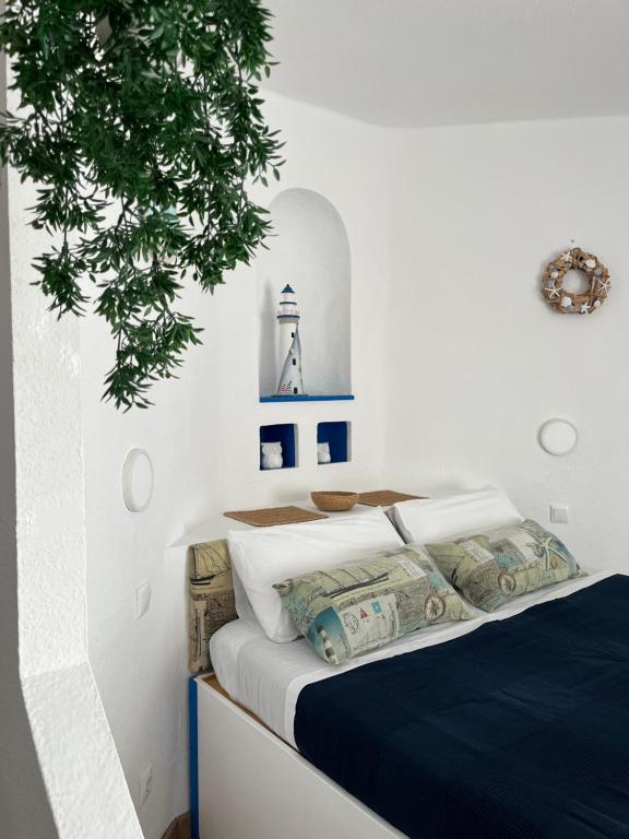 1 dormitorio con 1 cama y un faro en la pared en Piera's Paraiso Seaview, en Playa Paraiso