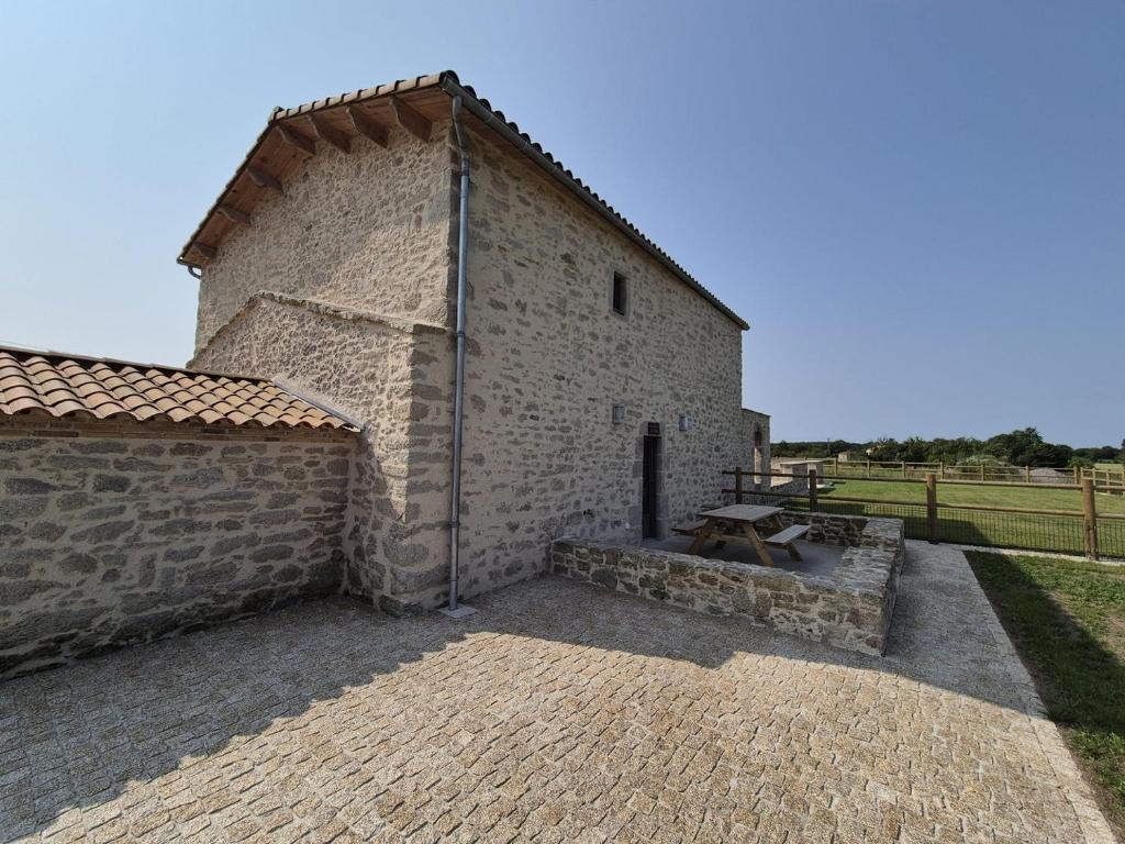 - un grand bâtiment en pierre avec un mur en briques dans l'établissement Gîte Cosy & Nature - 4 Pers - proche Puy du Fou, à La Bruffière