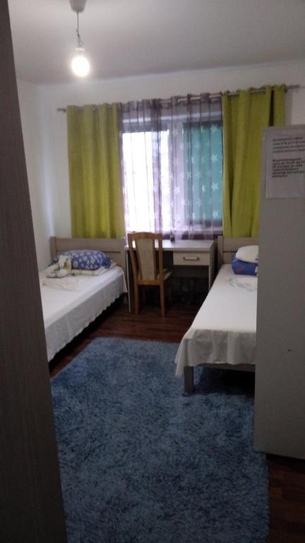 a room with two beds and a desk and a table at Tanagra- POKOI in Poznań