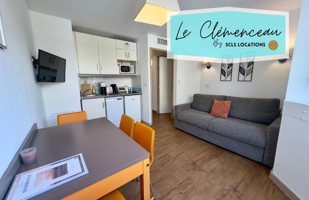 Il dispose d'une cuisine et d'un salon avec une table et un canapé. dans l'établissement Le Clemenceau - SCLS Locations, à Cannes