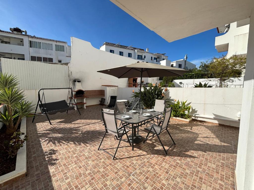 ein Tisch und Stühle mit einem Sonnenschirm auf einer Terrasse in der Unterkunft Santa Eulália Terrace in Albufeira