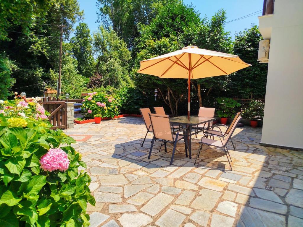 a table and chairs with an umbrella on a patio at Elias Studio & Apartment near Papa Nero Beach Pelion in Agios Ioannis Pelio