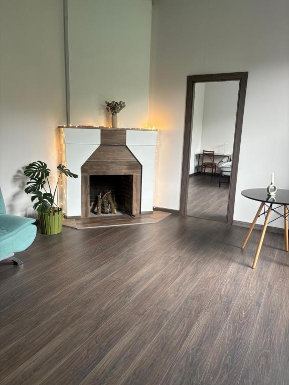 a living room with a fireplace and a mirror at Cozy place in mountains of Ajaria in Kokhi