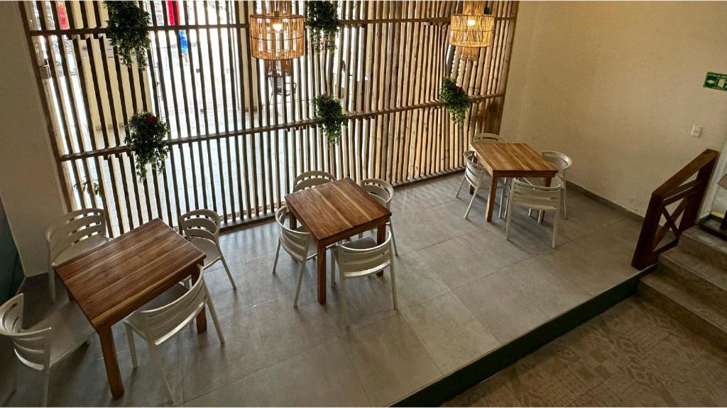 サン・アンドレスにあるHotel Tower by On vacationの木製のテーブルと椅子が置かれた部屋にあるレストラン