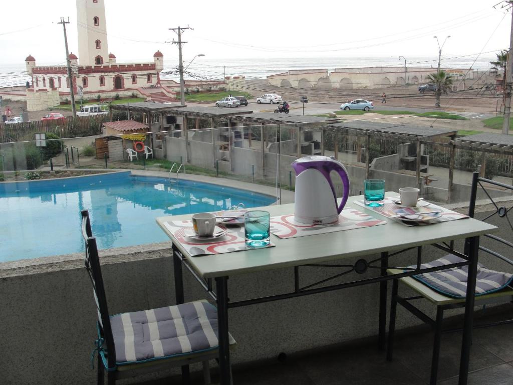 una mesa con un hervidor de agua en un balcón con piscina en Mirador El Faro, en La Serena