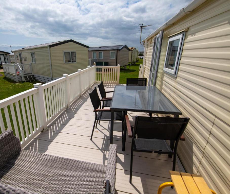 a deck with a table and chairs on a house at WW213 - 4 bed, Parkdean Camber in Camber