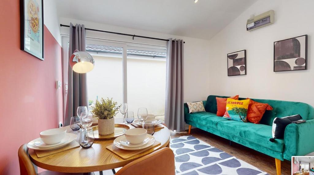 a living room with a green couch and a table at Central & Modern - Fast WIFI - 5 Min to Centre in Cardiff