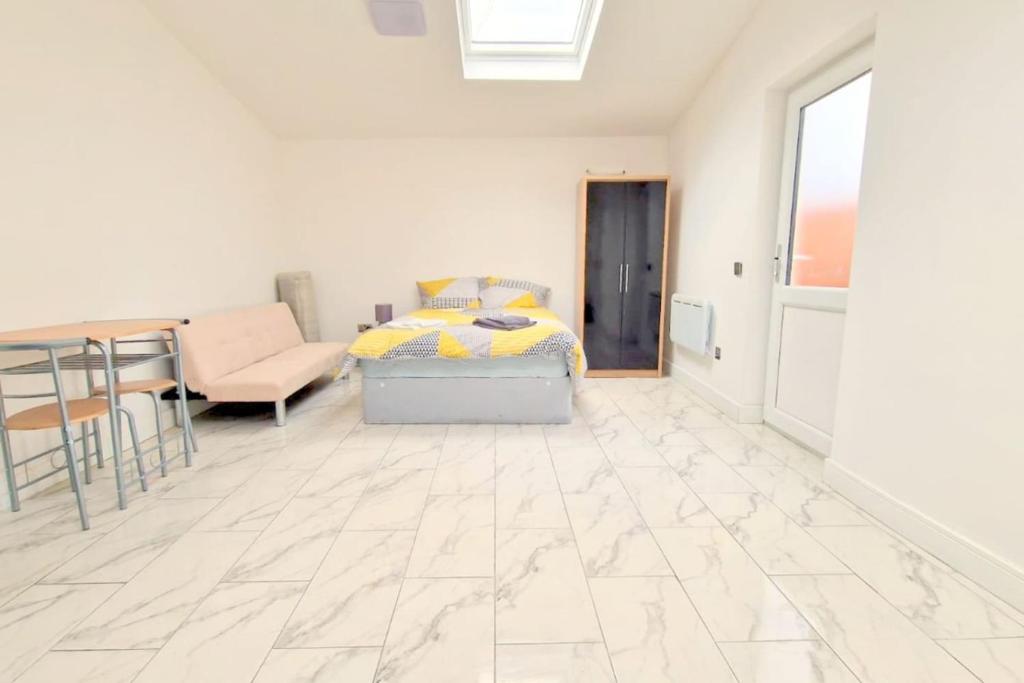 HackbridgeにあるHuge 7-bedroom House in Croydonのベッドとテーブルのあるリビングルーム