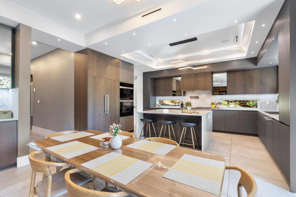 una cucina e una sala da pranzo con tavolo e sedie in legno di 2505 Edgemont Blvd.- Anupoju a North Vancouver