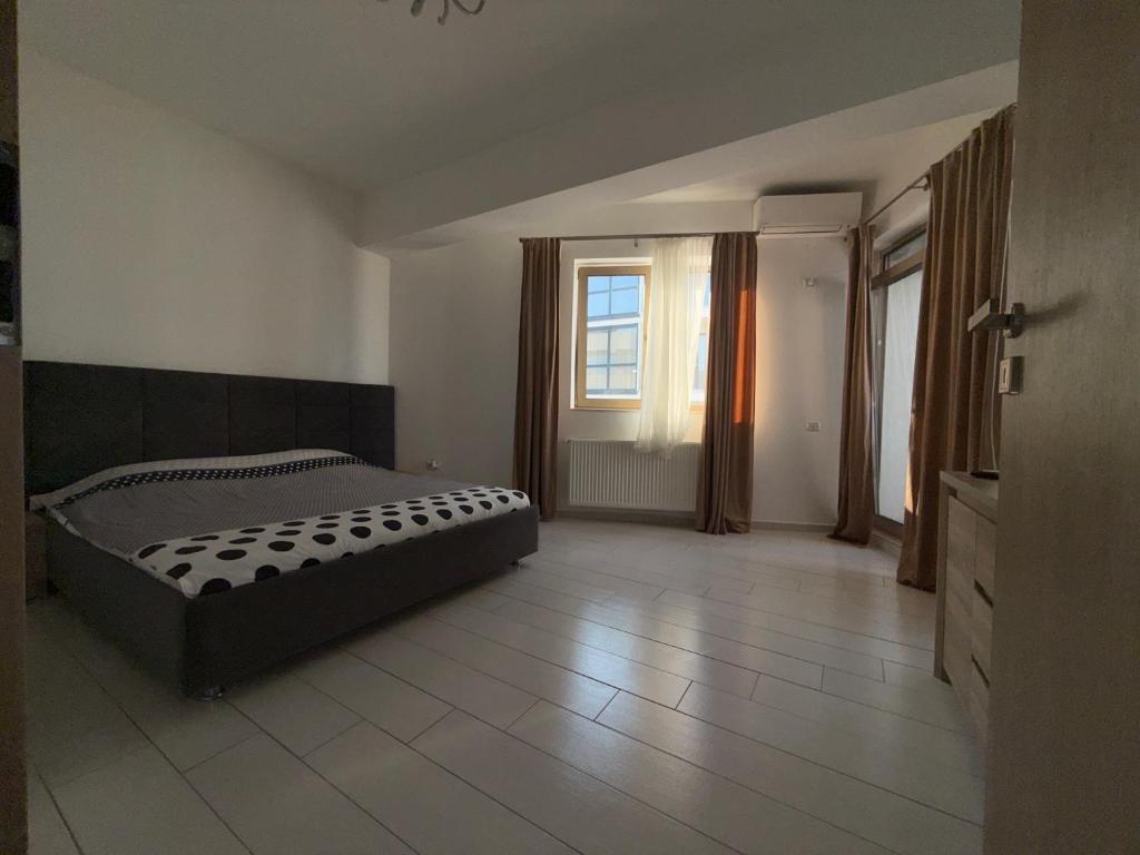 a large bedroom with a bed and a window at White Luxury Apartament in Mamaia Nord