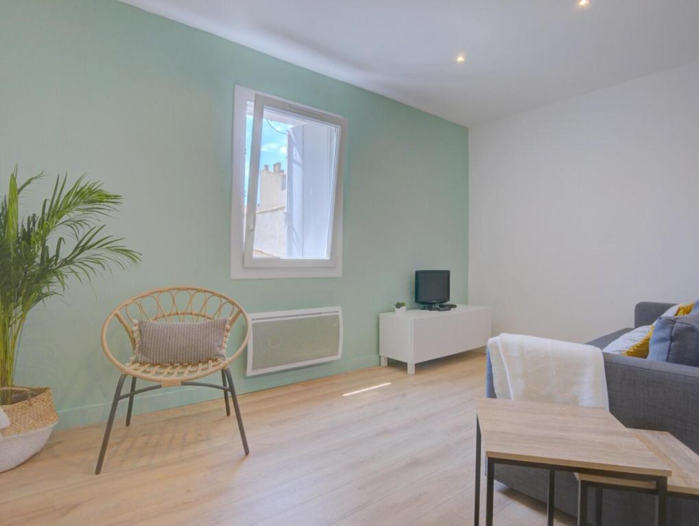 un salon avec un canapé et une chaise dans l'établissement Charmant deux pièces en cœur de ville, à Sète