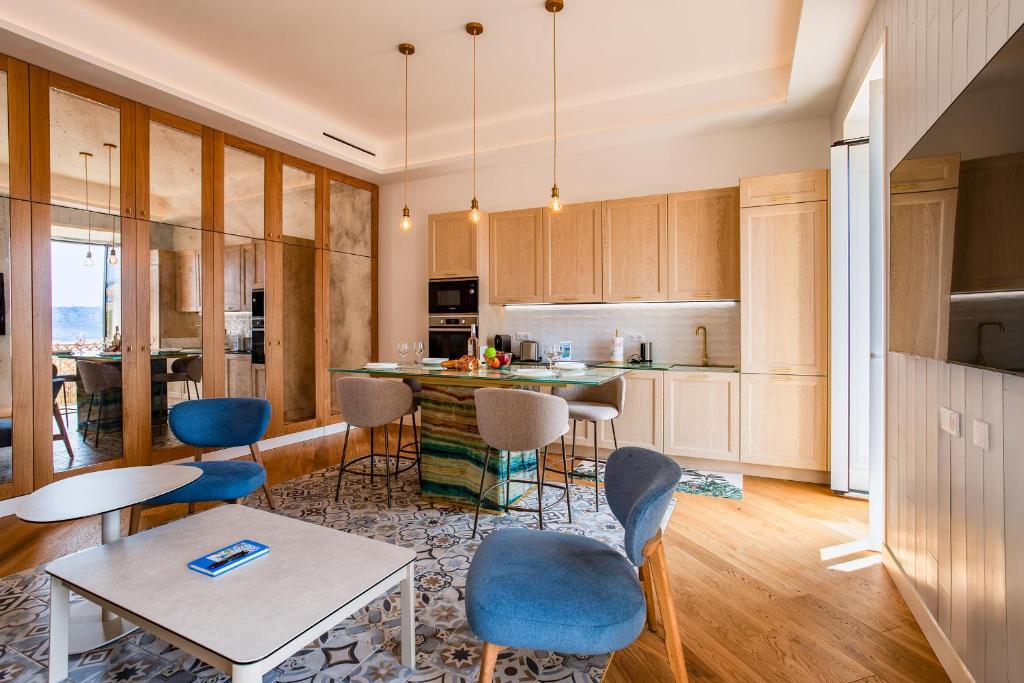 une cuisine avec des armoires en bois et une table et des chaises dans l'établissement BAY VIEW AP4470 By Riviera Holiday Homes, à Villefranche-sur-Mer