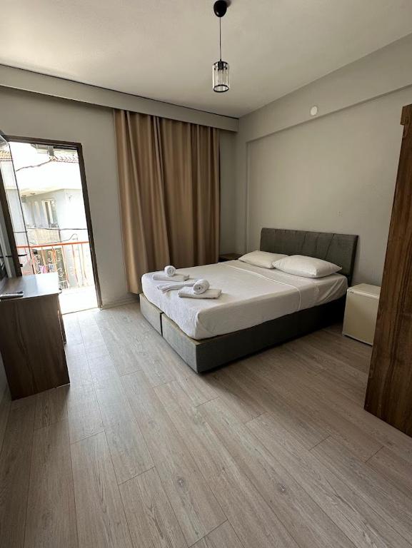 a bedroom with a bed and a large window at Viyana otel in Cesme