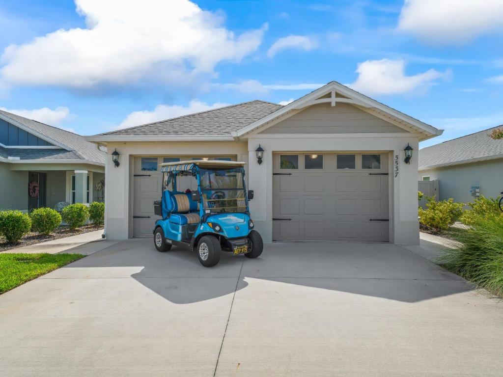 a golf cart parked in front of a house at 5537 Z6 HAMMOCK AT FENNEY by REMAX PREMIER REALTY in The Villages