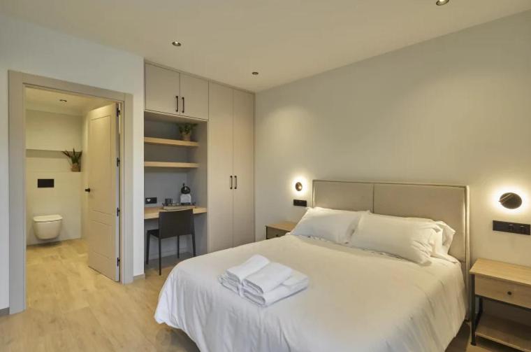 a bedroom with a large white bed and a desk at El Merendero de Burgos 