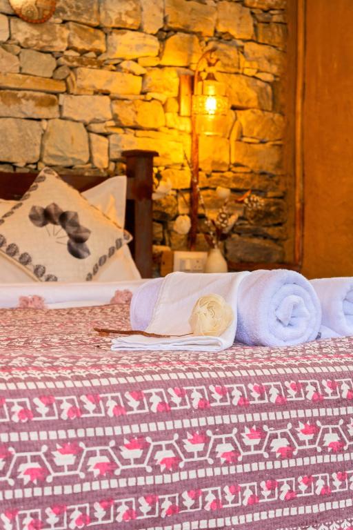 a doll sitting on top of a bed with towels at Himalayan Willow in Gushaini