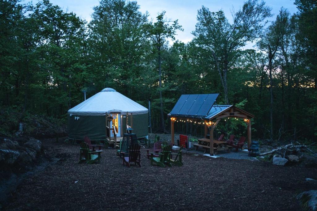 a gazebo with chairs and a table and a tent at Spacious Yurt in the Woods in Sainte-Agathe-des-Monts