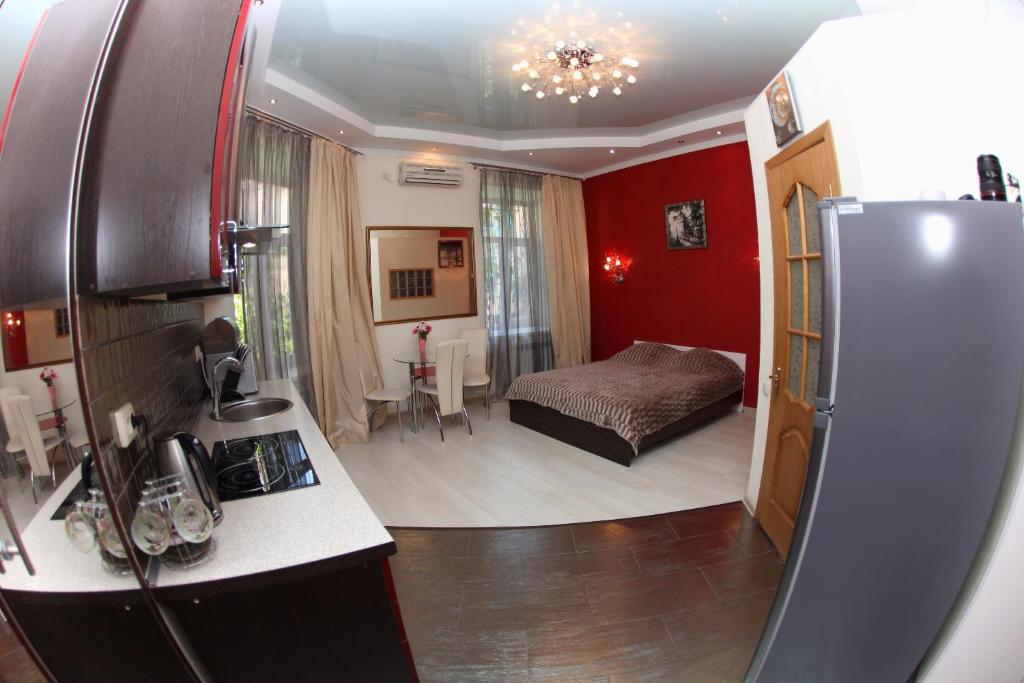 a kitchen with a refrigerator and a bedroom with a bed at Apartments De-Ribas in Odesa