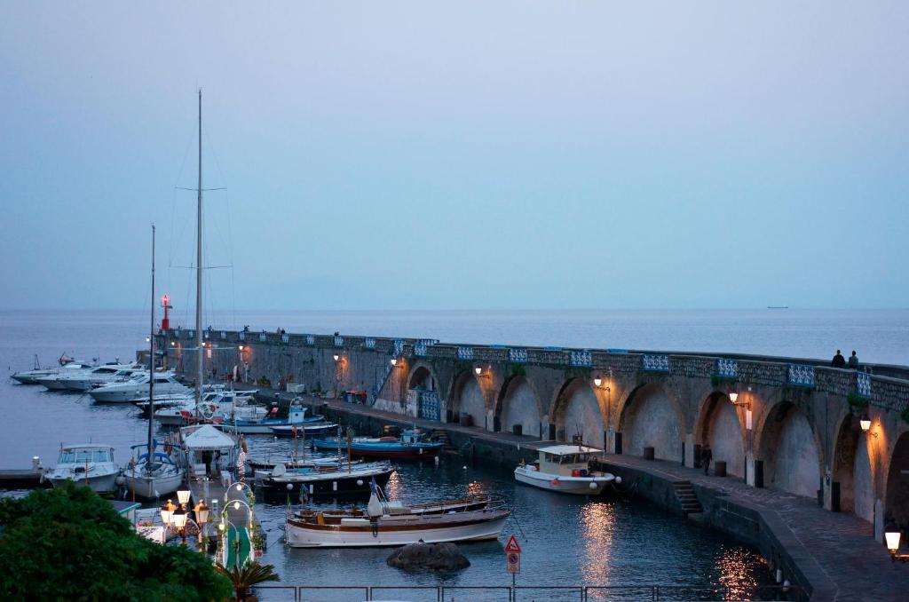 a group of boats in the water near a bridge at Hotel Aurora in Amalfi