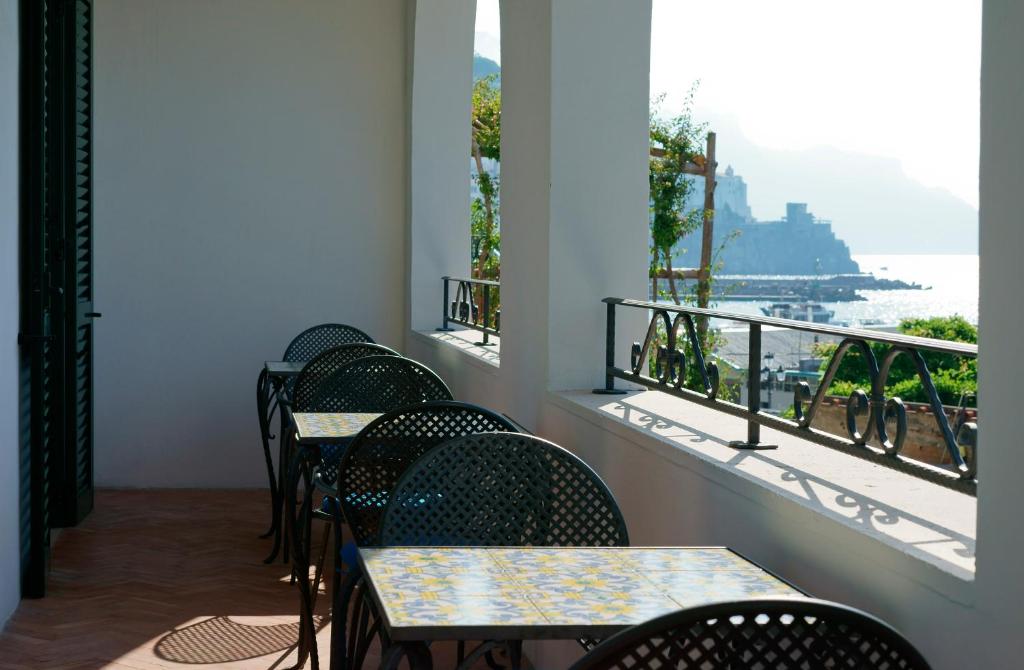 a row of tables and chairs with a view of the ocean at Hotel Aurora in Amalfi