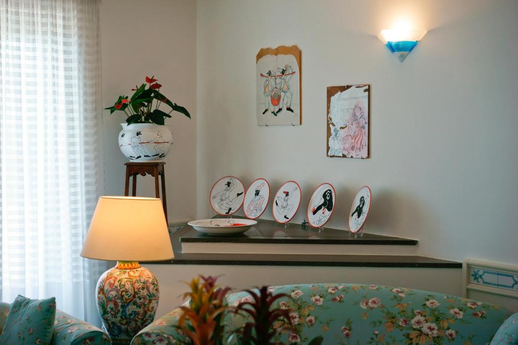 a living room with a table with plates on the wall at Hotel Aurora in Amalfi