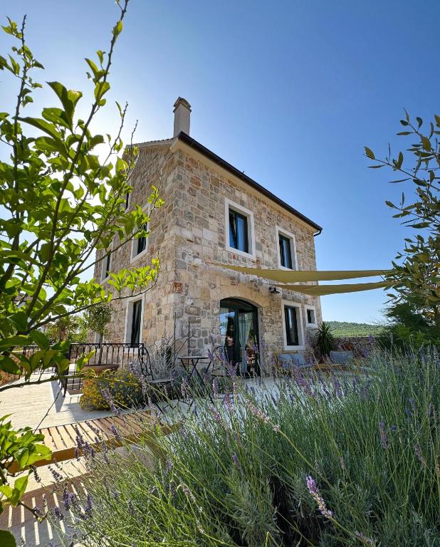 an old stone house in the middle of a field at Villa Šjora - ''Autentic Dalmatian Stone Villa with Private Garden & BBQ'' in Vrboska