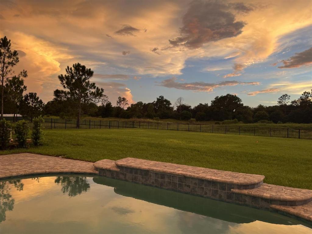 a pool of water in a field with a sunset at Waterski and More in Clermont