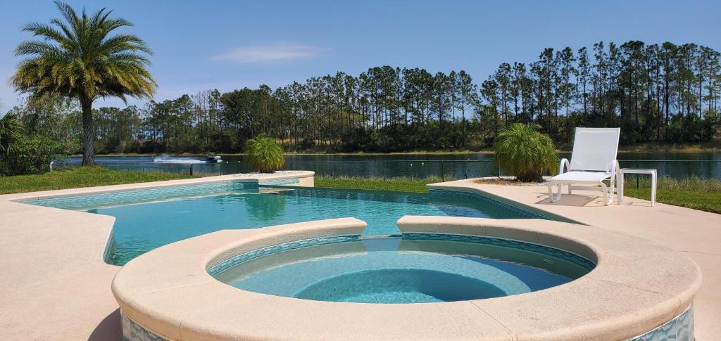 a swimming pool with a chair next to a lake at Citrus Breeze in Clermont