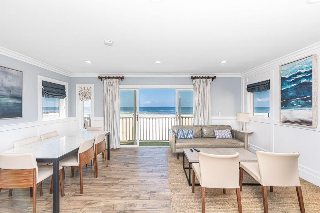 a dining room with a table and chairs and the ocean at Modern 3Br Oceanfront W Rooftop Deck & Panoramic Views By Beachview Rentals in Newport Beach