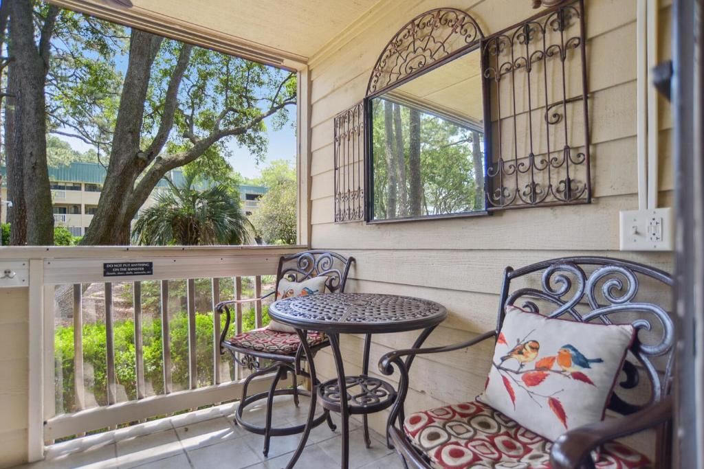 a balcony with a table and chairs and a window at Beachside Bliss Villa with Pools & Tennis in Hilton Head Island