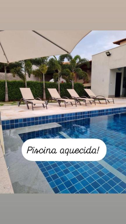 a swimming pool with chaise lounge chairs next to a pool at Casa Tô D`Boa Capitólio in Capitólio