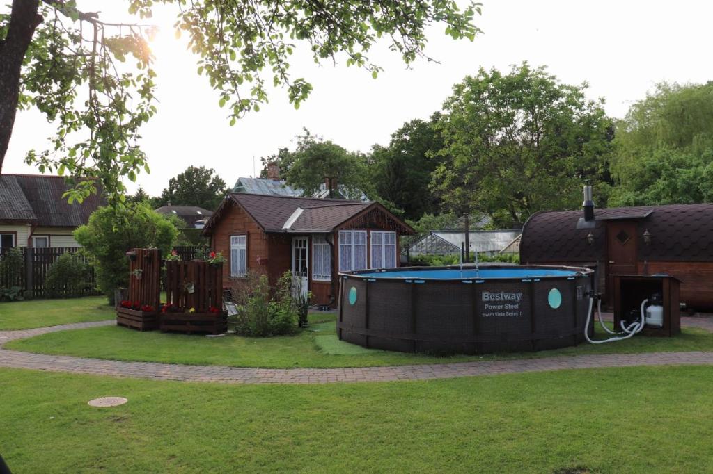 a pool in a yard next to a house at Strazdu Māja in Jūrmala