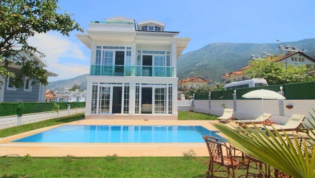 a house with a swimming pool in the yard at Oludeniz Villa with Private Pool in Fethiye