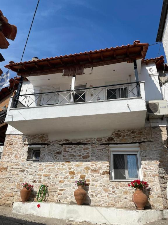 a building with a balcony and potted plants on it at Soti's House in Kallirákhi