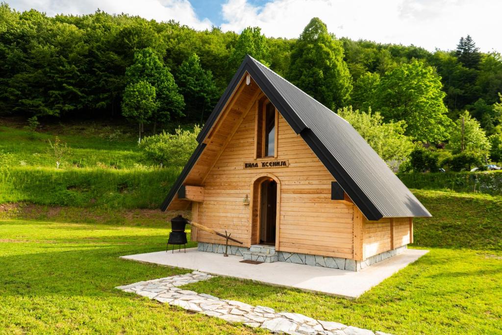 a small cabin with a black roof on a grass field at Wolf's PEAK in Kolašin