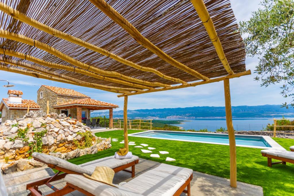 a patio with a view of a pool and a house at Vila Mare in Risika