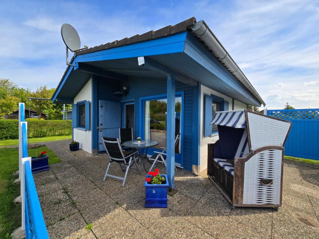 a blue tiny house with a table and chairs at Ferienhaus Küstenzauber Simonsberg Nordsee Meer Husum in Simonsberg