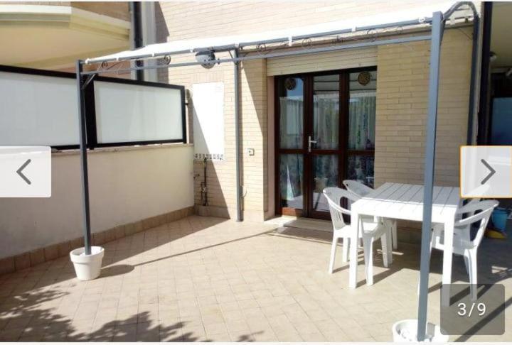 a patio with a white table and chairs on a patio at Casetta al mare in Cupra Marittima