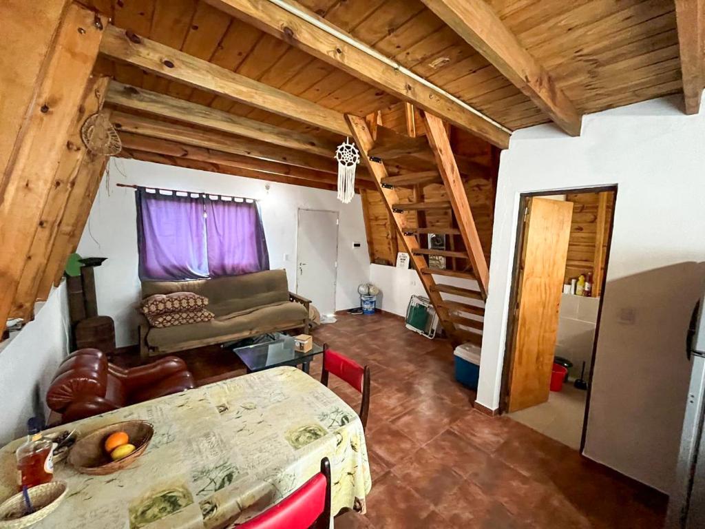 a living room with a table and a couch at Alquiler en Chapadmalal en el barrio "El Marquesado" in San Eduardo del Mar