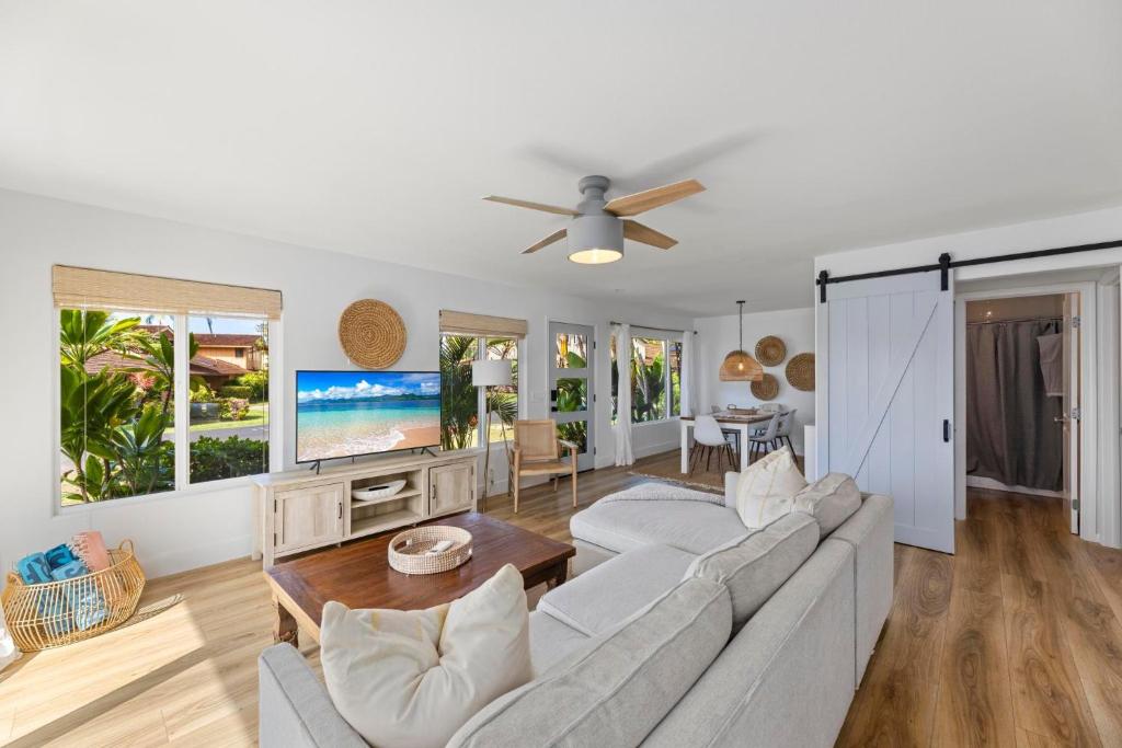 a living room with a couch and a tv at Puamana 111-2 Superior Ocean View in Lahaina
