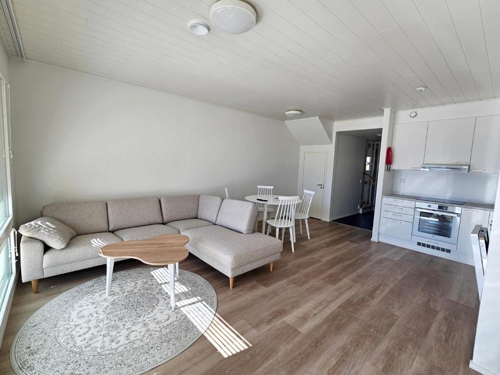 un soggiorno con un divano e un tavolo di Heim Apartments - Rivitalo a Seinäjoki