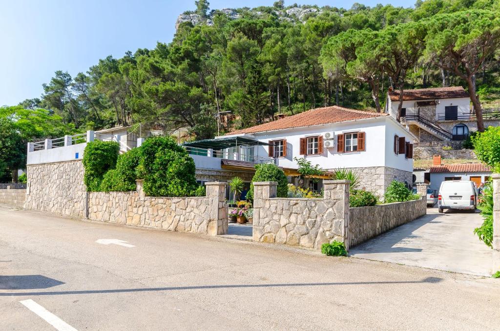 a house on a hill with a stone wall at Apartment Kokic in Zastražišće